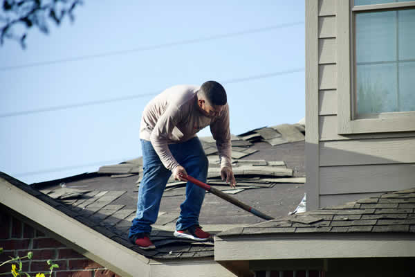 man on roof rooming shingles